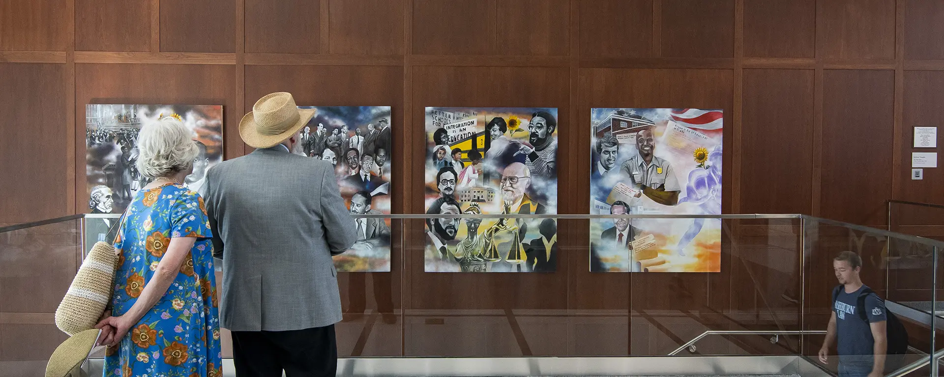 Two people look at the Brown vs. Board mural in the Law school.