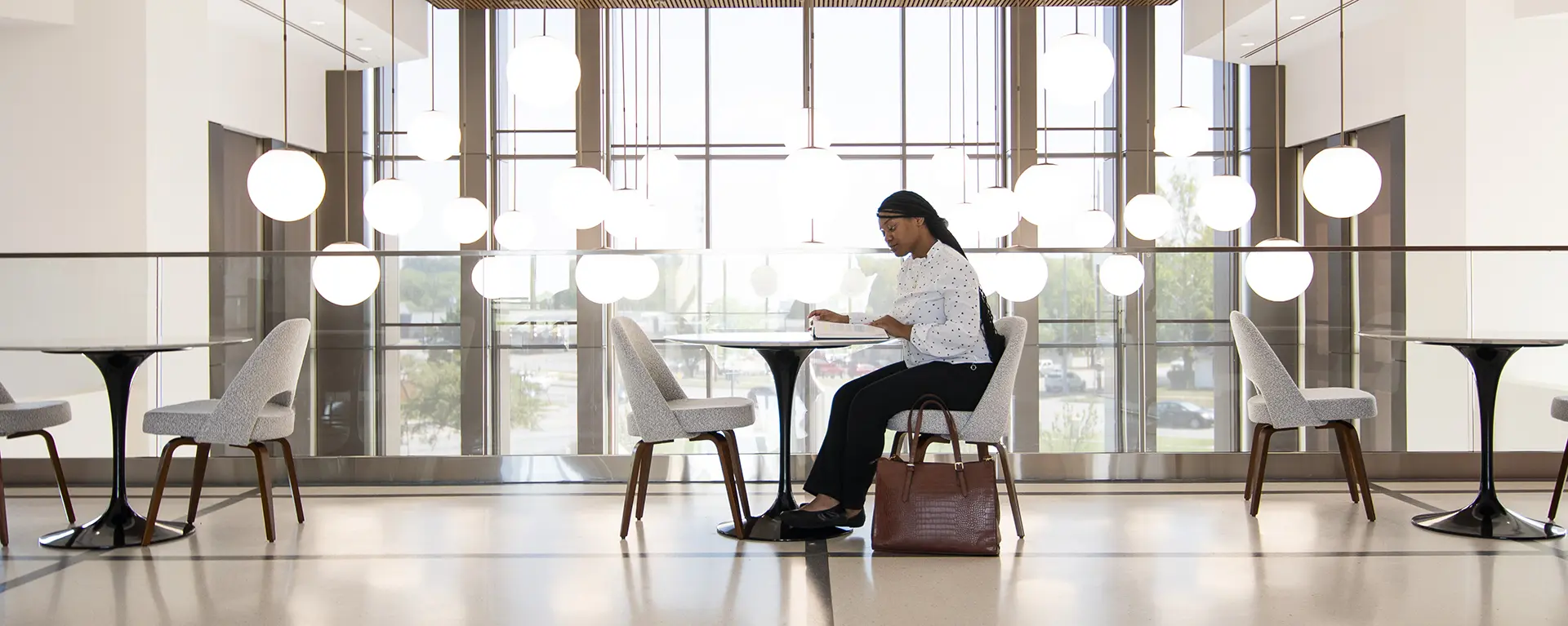 A student studies at a table overlooking the Dole Hall student commons. 