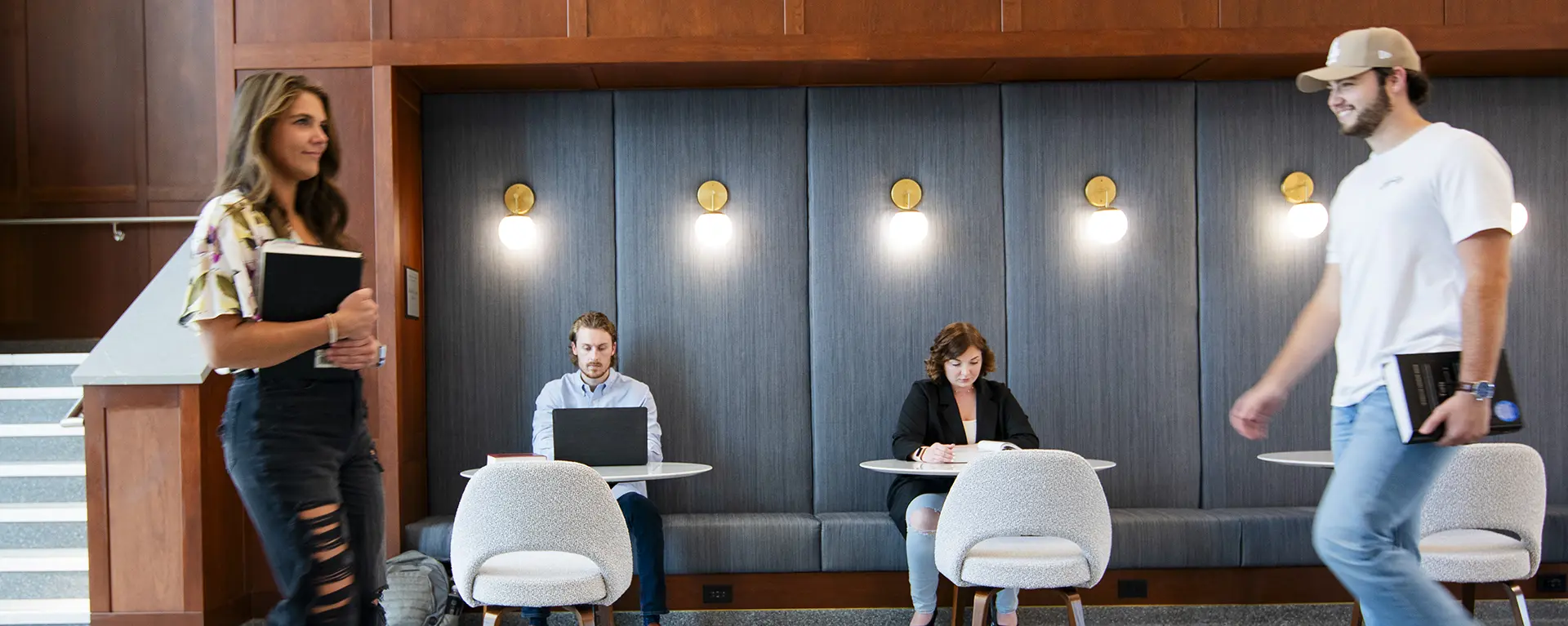 Students study in the lobby while others walk by.