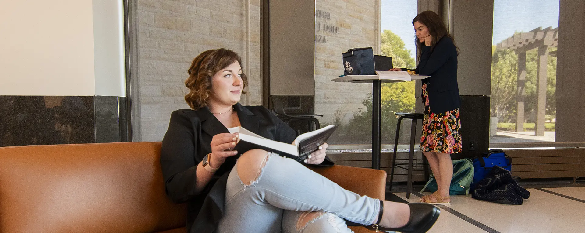 Student sitting on couch in student commons studying. 