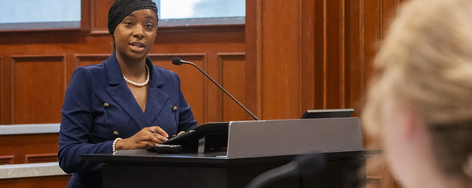 A law student speaks to a witness on the stand.