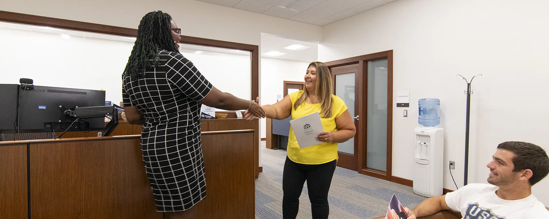 A student shakes hands with a recruiter.