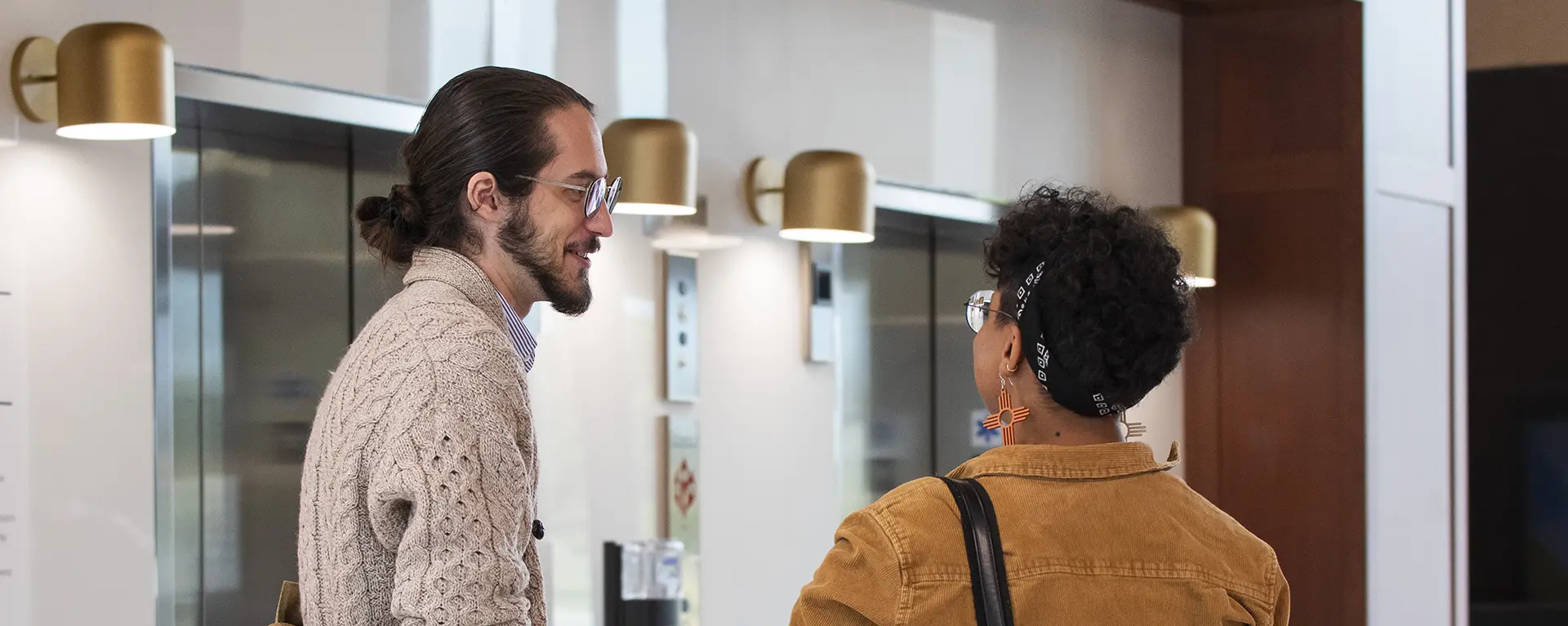 Two law students talk in the Dole Hall lobby.