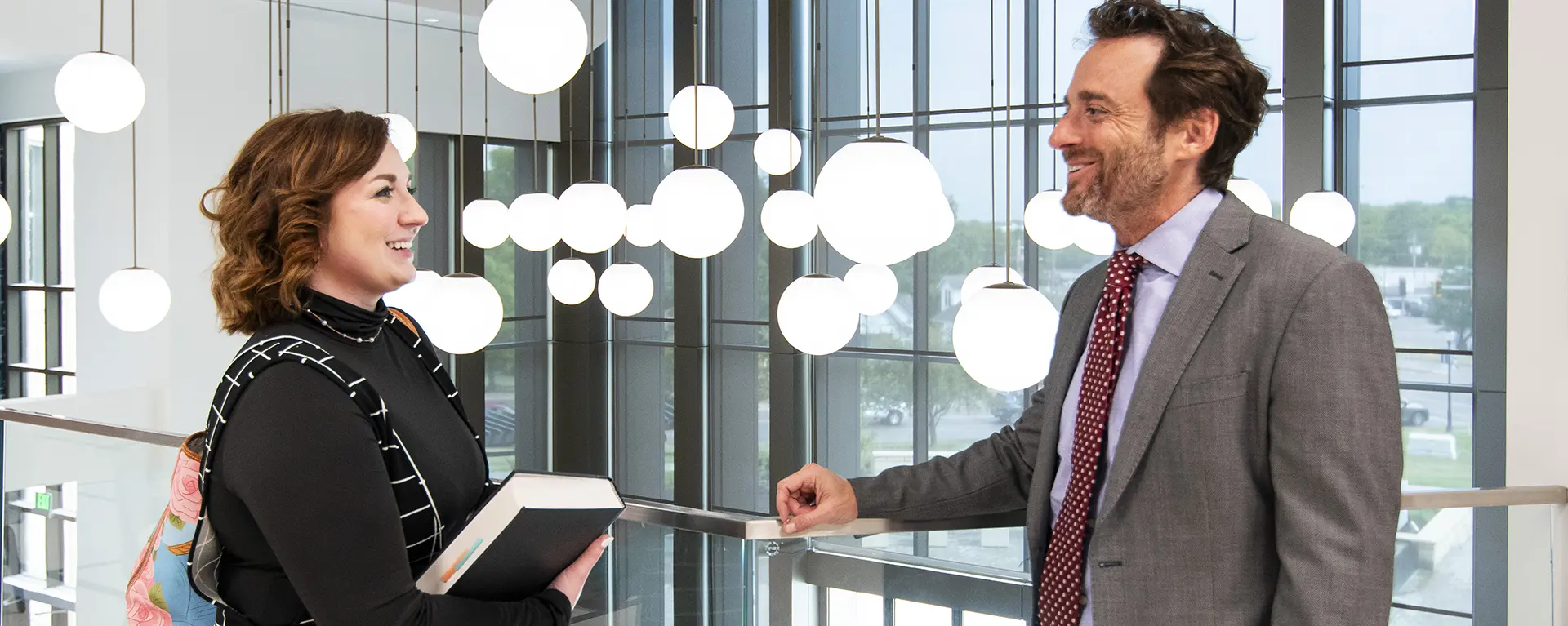 A professor and student chat in the lobby.