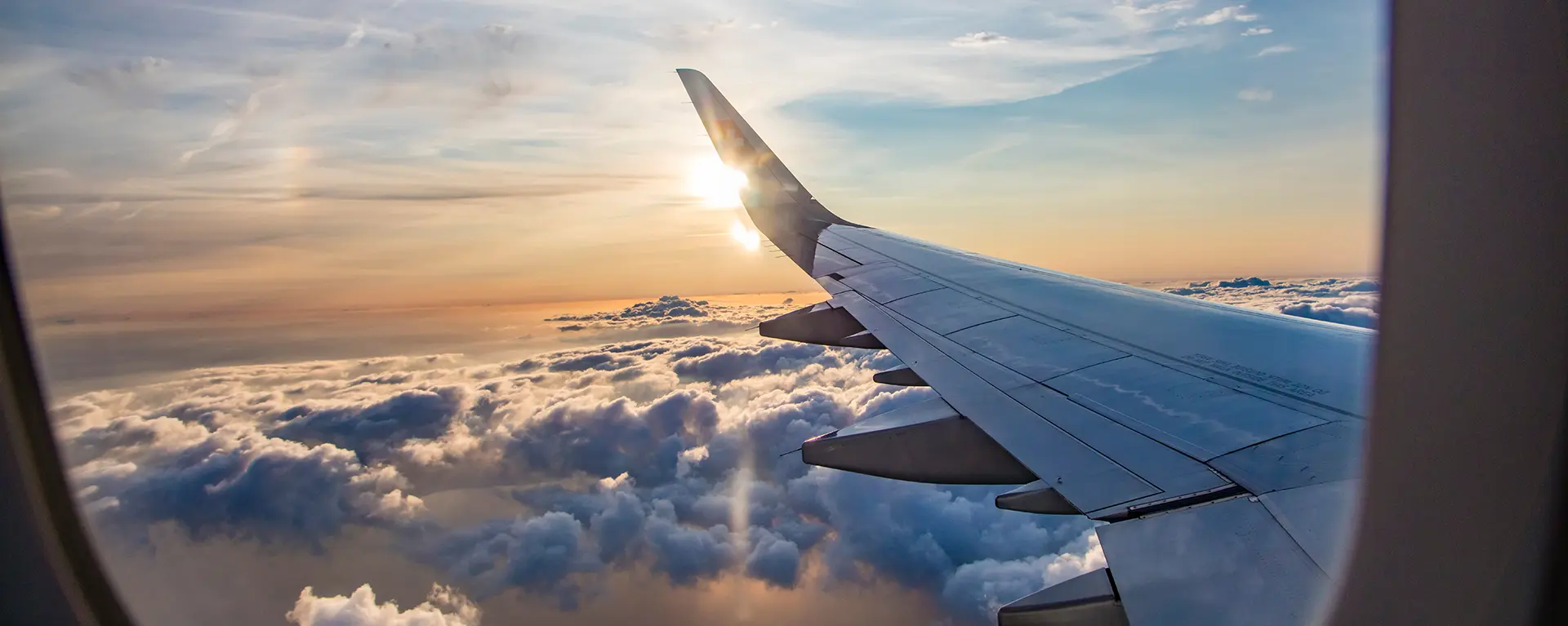 Airplane wing outside of window at sunset. 