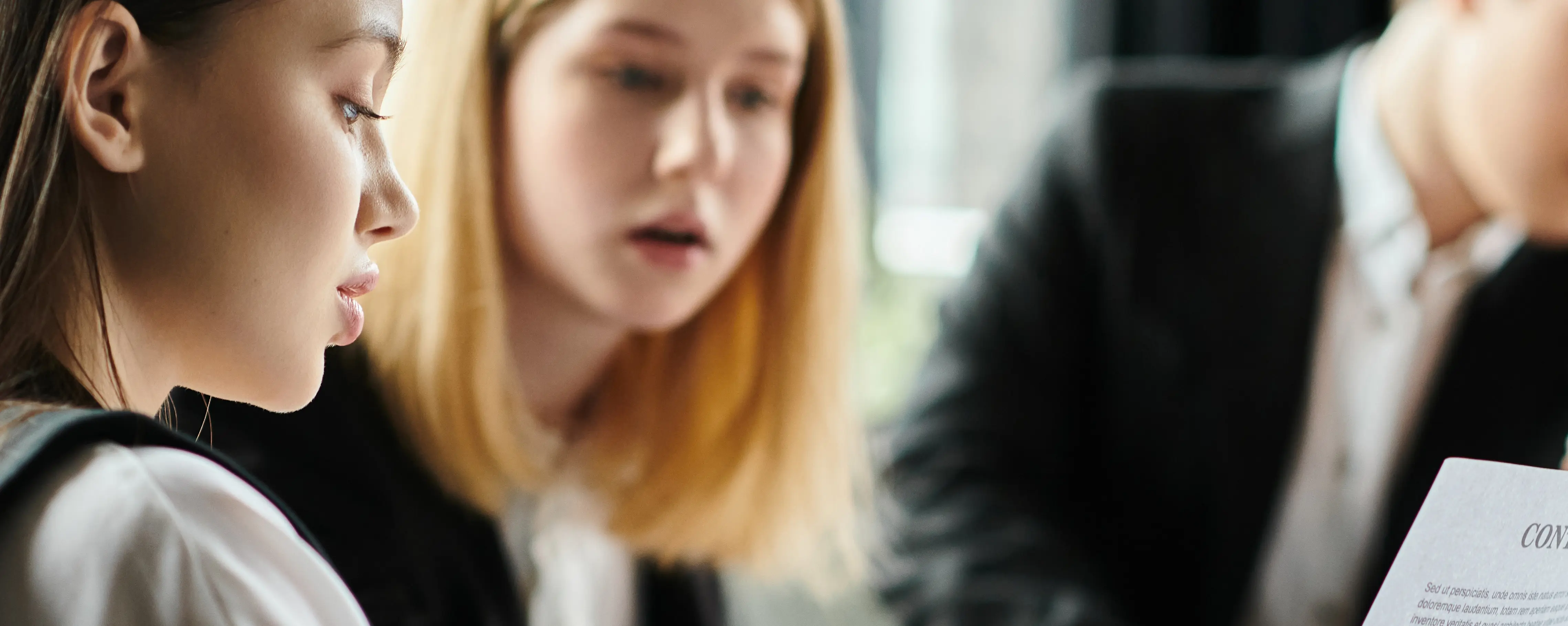 Two students compare notes in classroom. 