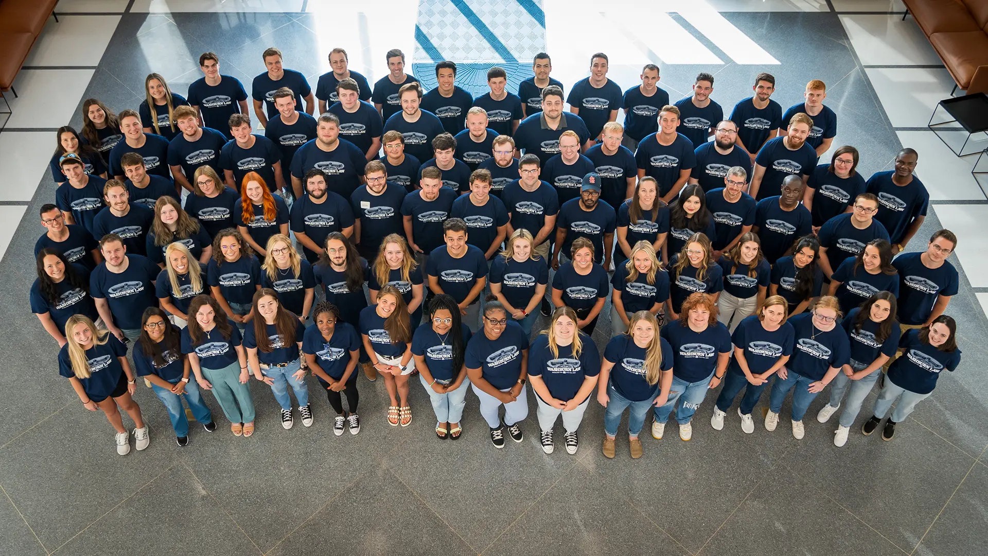 About 100 new law students smile for a class photo.