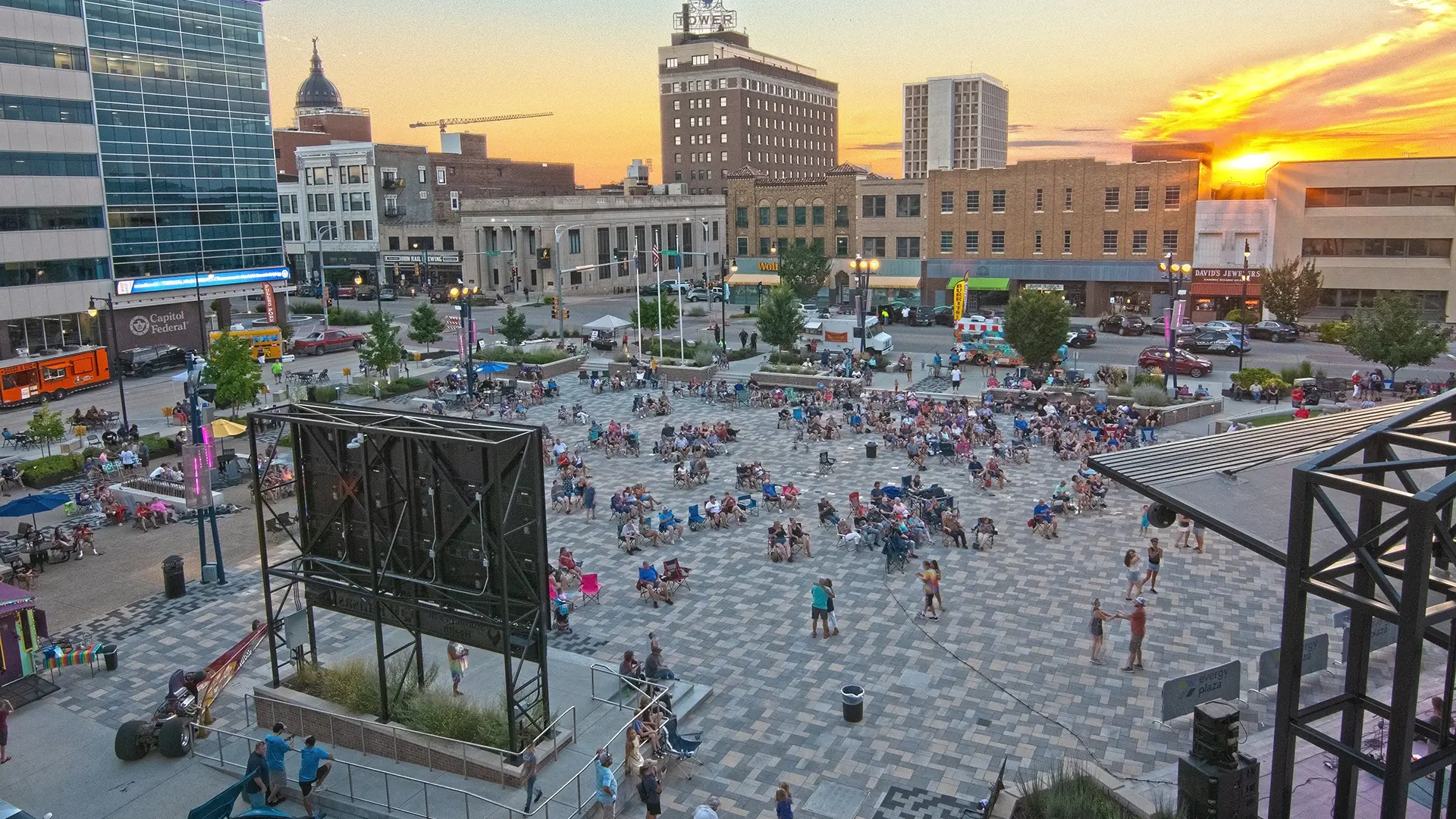 People dance during a concert at the dowtown Topeka plaza as the sun sets.