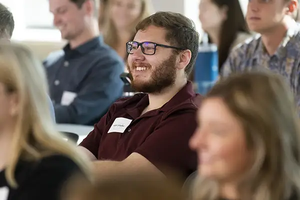 A student smiles and leans back in his chair while in class.