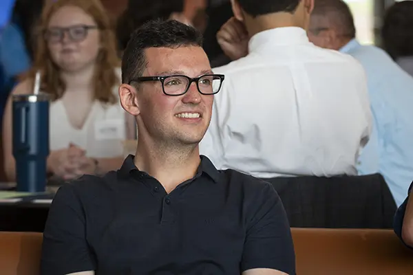 A student smiles in a class. 