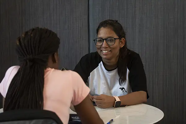 Two students chat while sitting down.