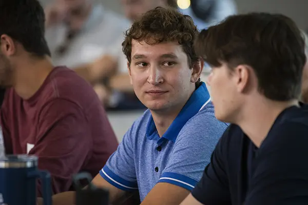 A student sits in a full classroom. 