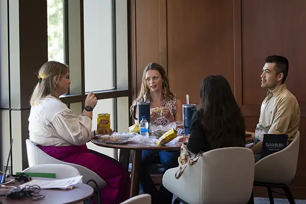 A small group of new law students and a mentor chat over lunch.