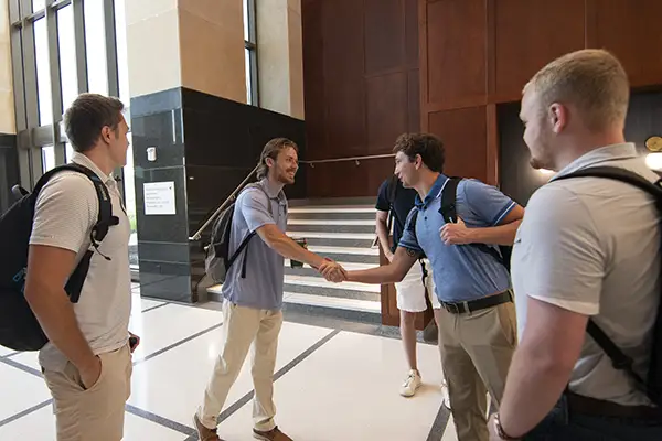 Students shake hands on the first day of law school.