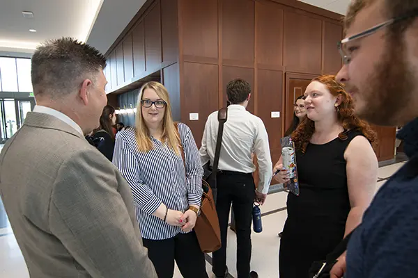 A group of students talk with a law professor.