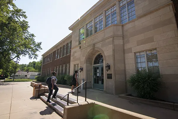 student walking up steps to Campus building