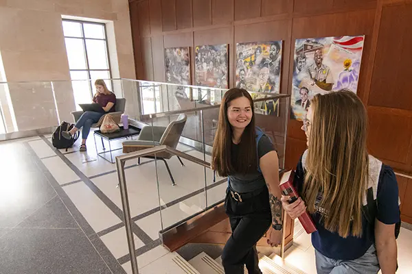 Student chat while walking up the stairs in Dole Hall.