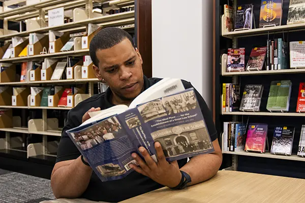 A law school student reads a book in the library.