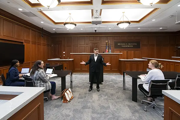 A law professor teaches students in the trial courtroom.