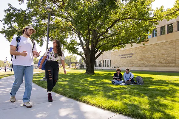 Students walk the trail around Dole Hall.