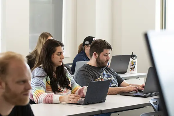 Students in classroom listening to lecture. 