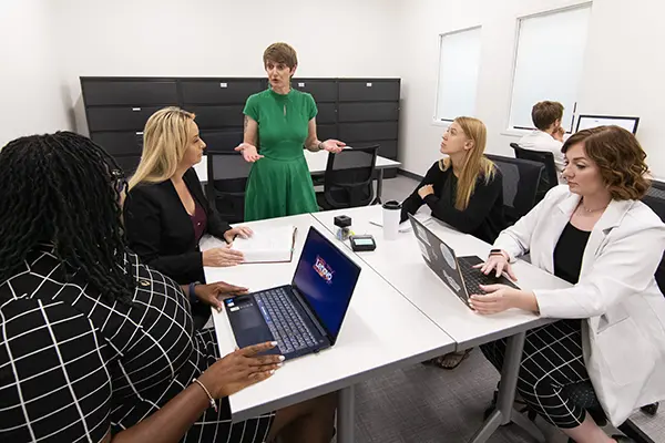 Students work with faculty member at Law Clinic conference table. 