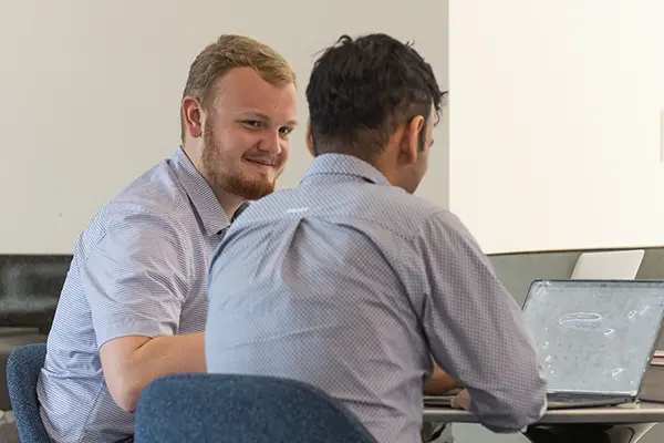 A student looks up from his studying to chat with another student.