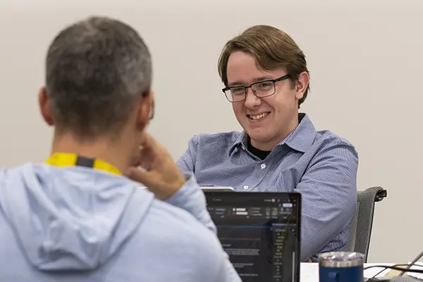 Two students smile and chat.