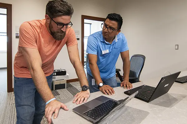 A law student works with the IT staff on his computer.