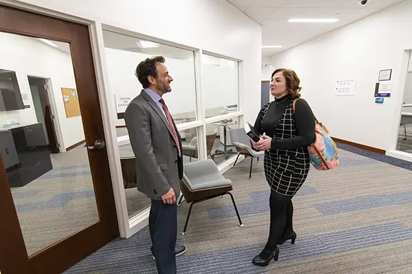 A professor meets with a student outside of classroom. 