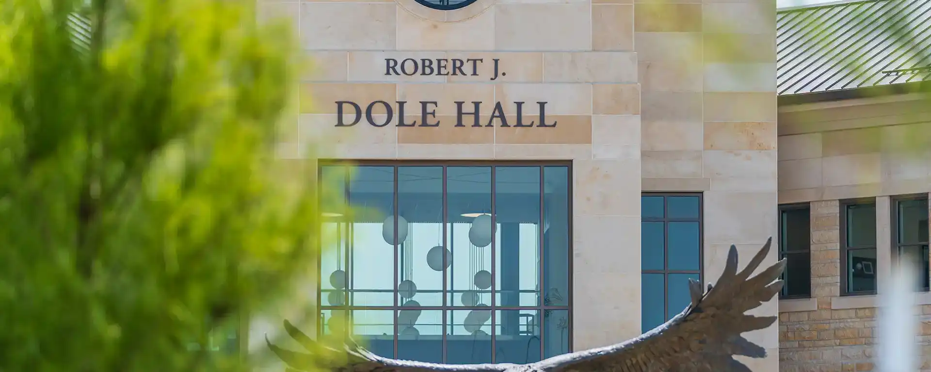 Closeup of Washburn Law building main entrance sign with unfocused treen in foreground